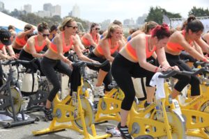 women of various body types in outdoor exercise spin class